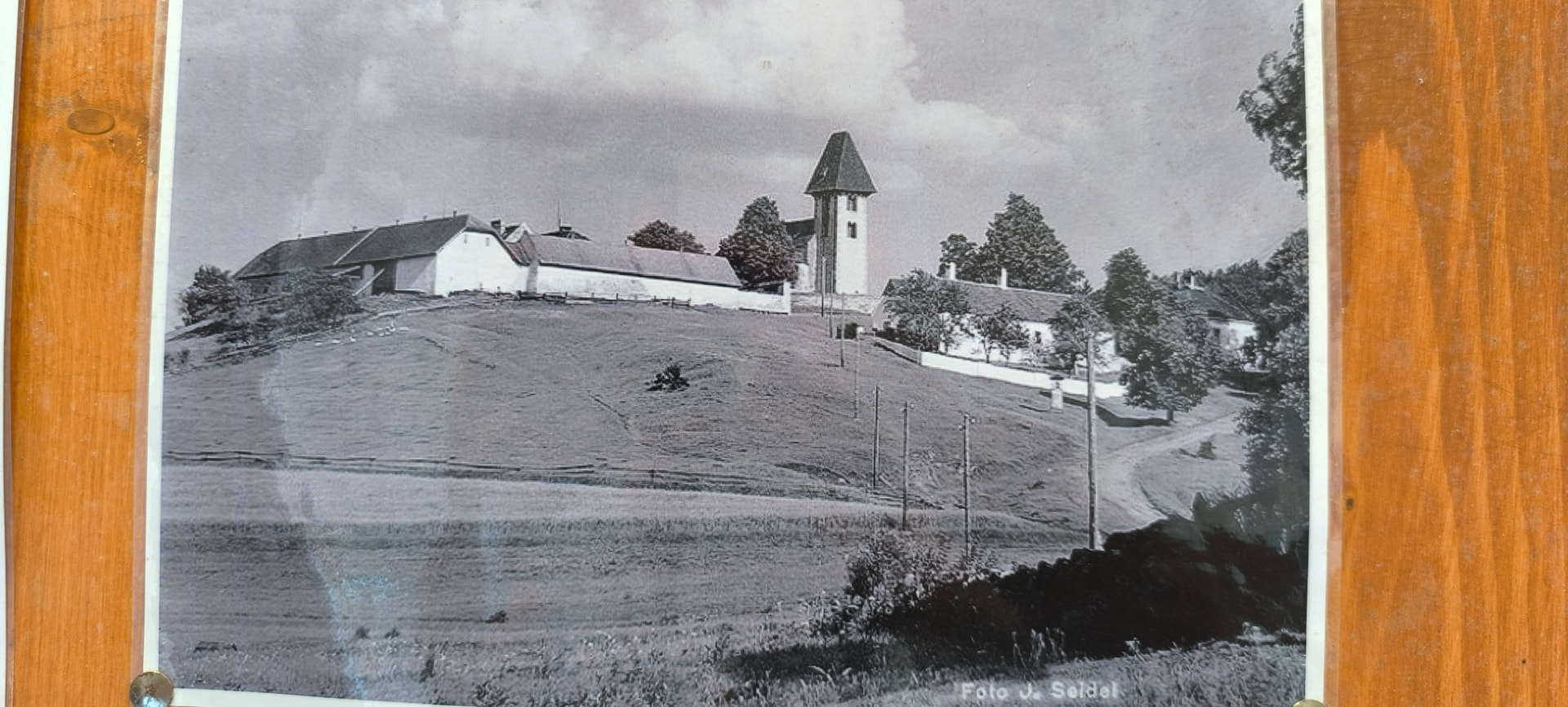 Historická černobílá fotografie Boletic s kostelem, farou a hospodářským dvorem