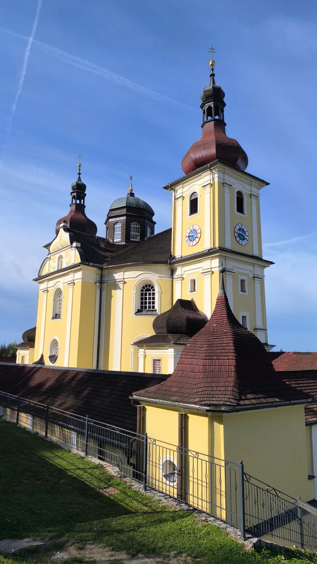 Boční pohled na poutní kostel na Dobré Vodě s věžemi a ambitem
