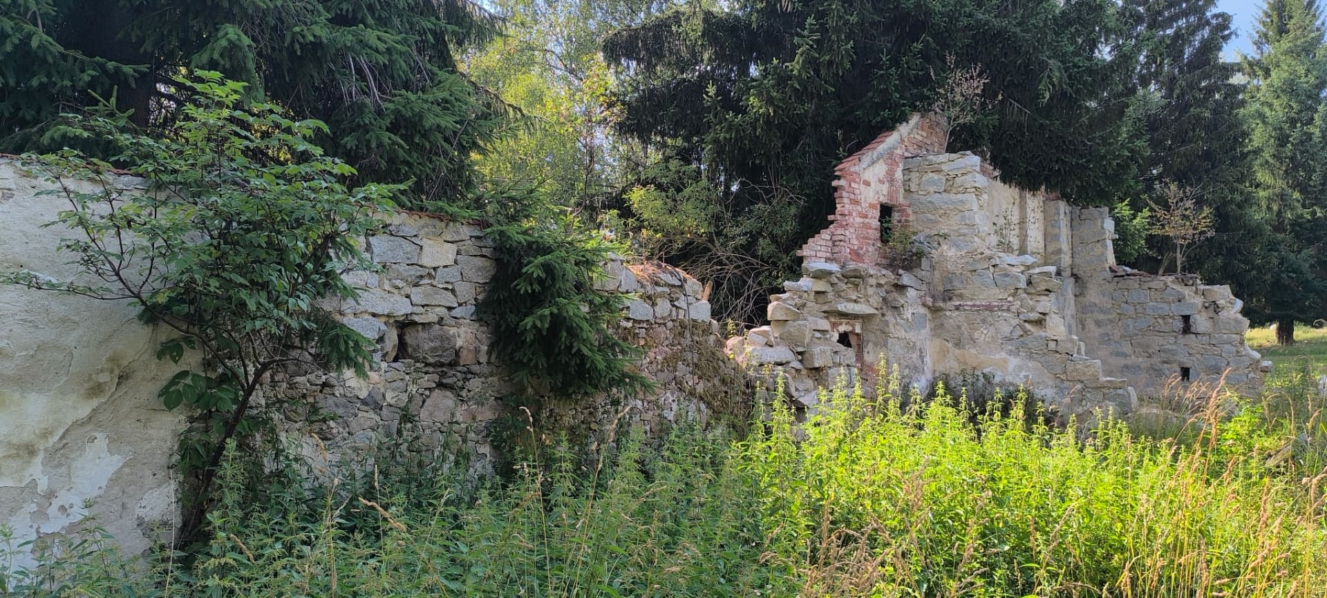 Zbytky zdiva jednoho z domů naproti kostelu v Cetvinách.