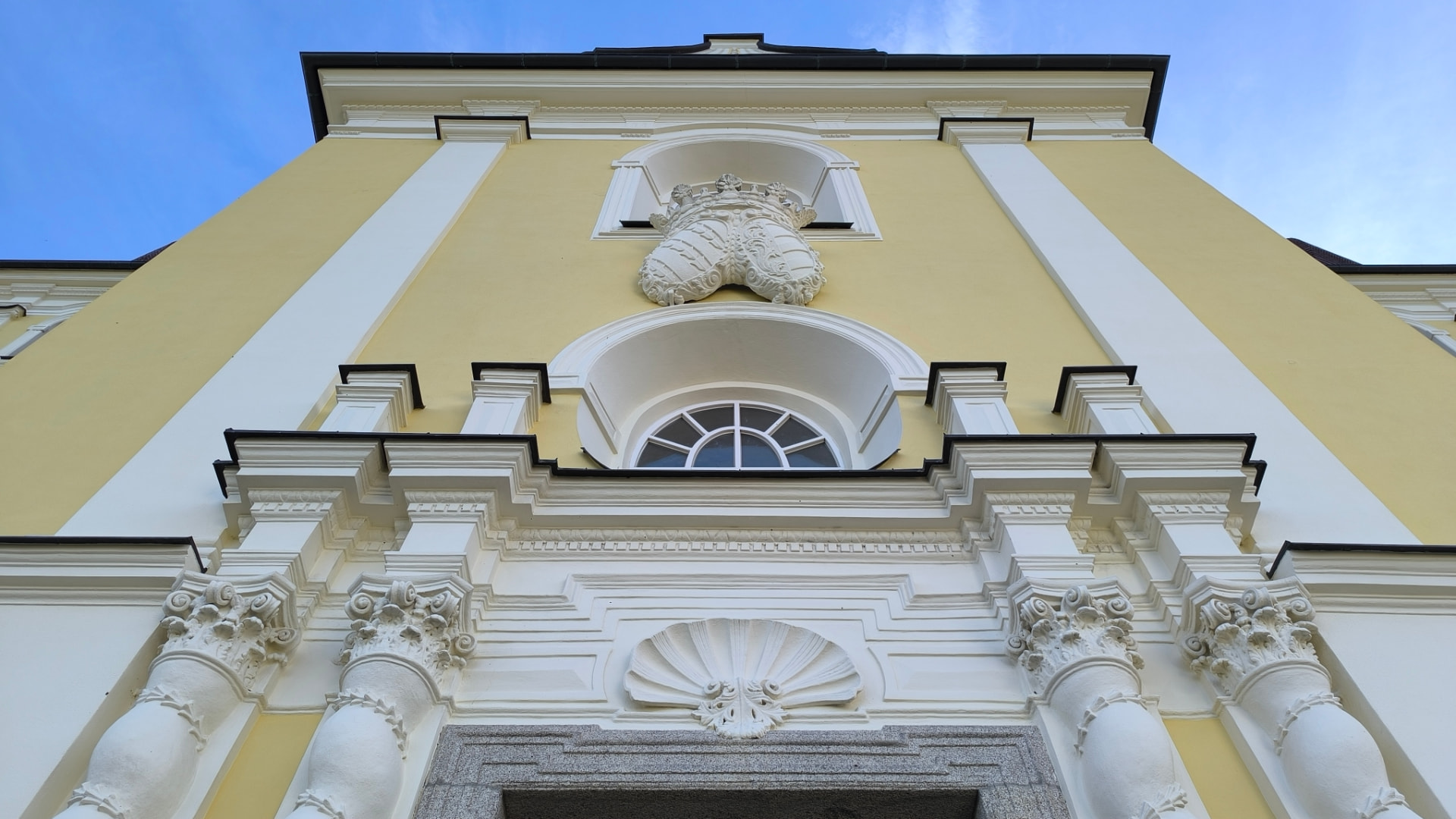 Detail barokního průčelí kostela na Dobré Vodě s erbem nad vstupem
