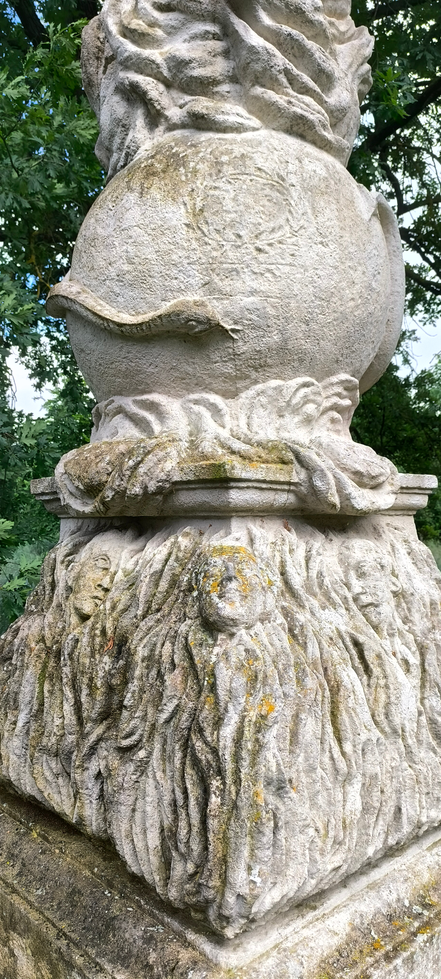 Detail podstavce s tvářemi v plamenech