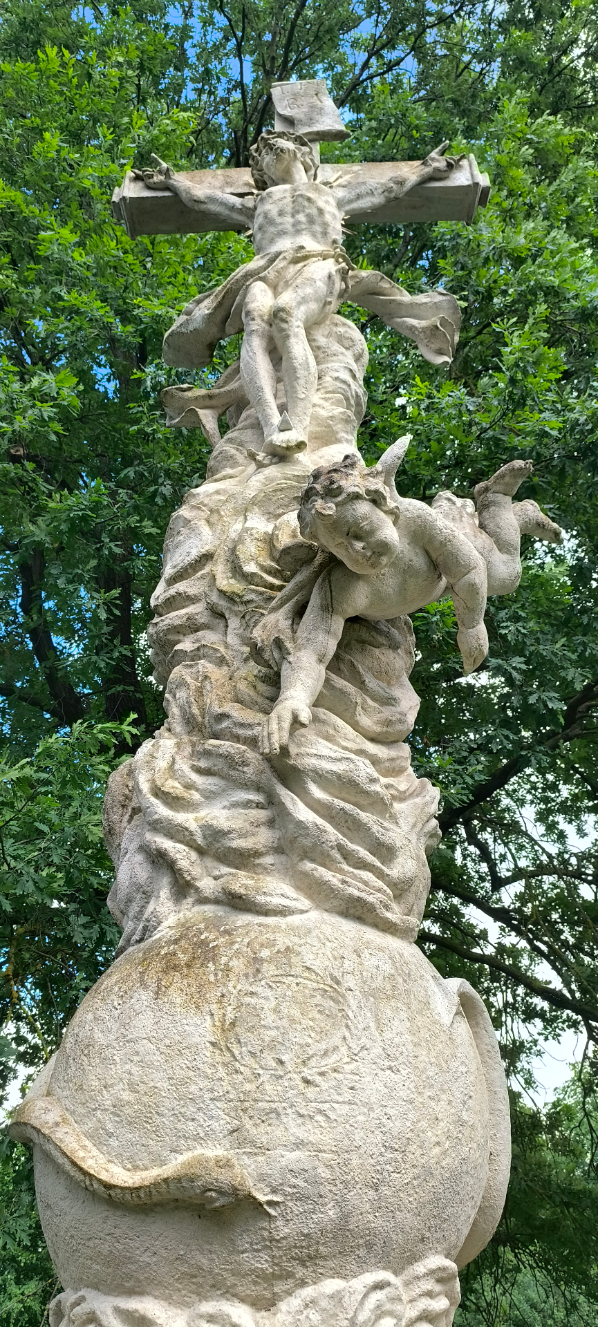 Detail vrcholu sousoší — kříž s andělem