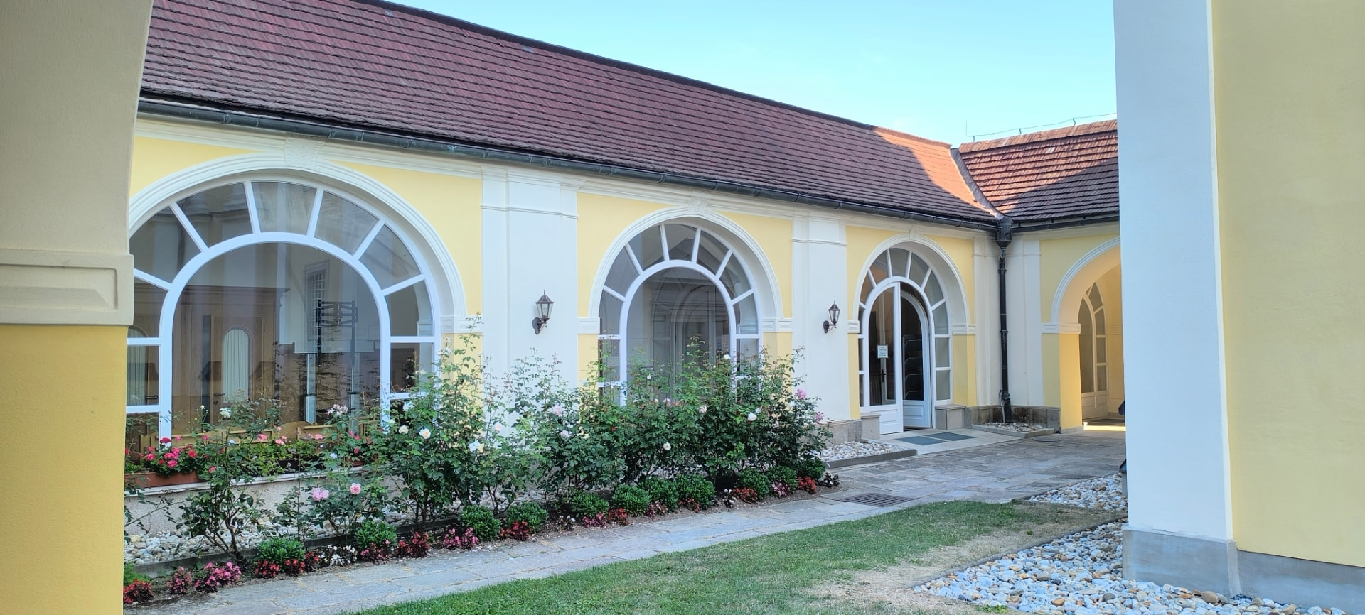 Ambit kolem kostela na Dobré Vodě s prosklenými oblouky a květinami